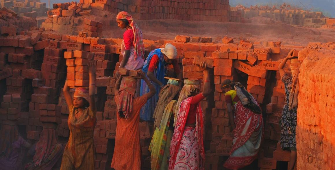 Kvinner som jobber med murstein i India. Foto: Unsplash.